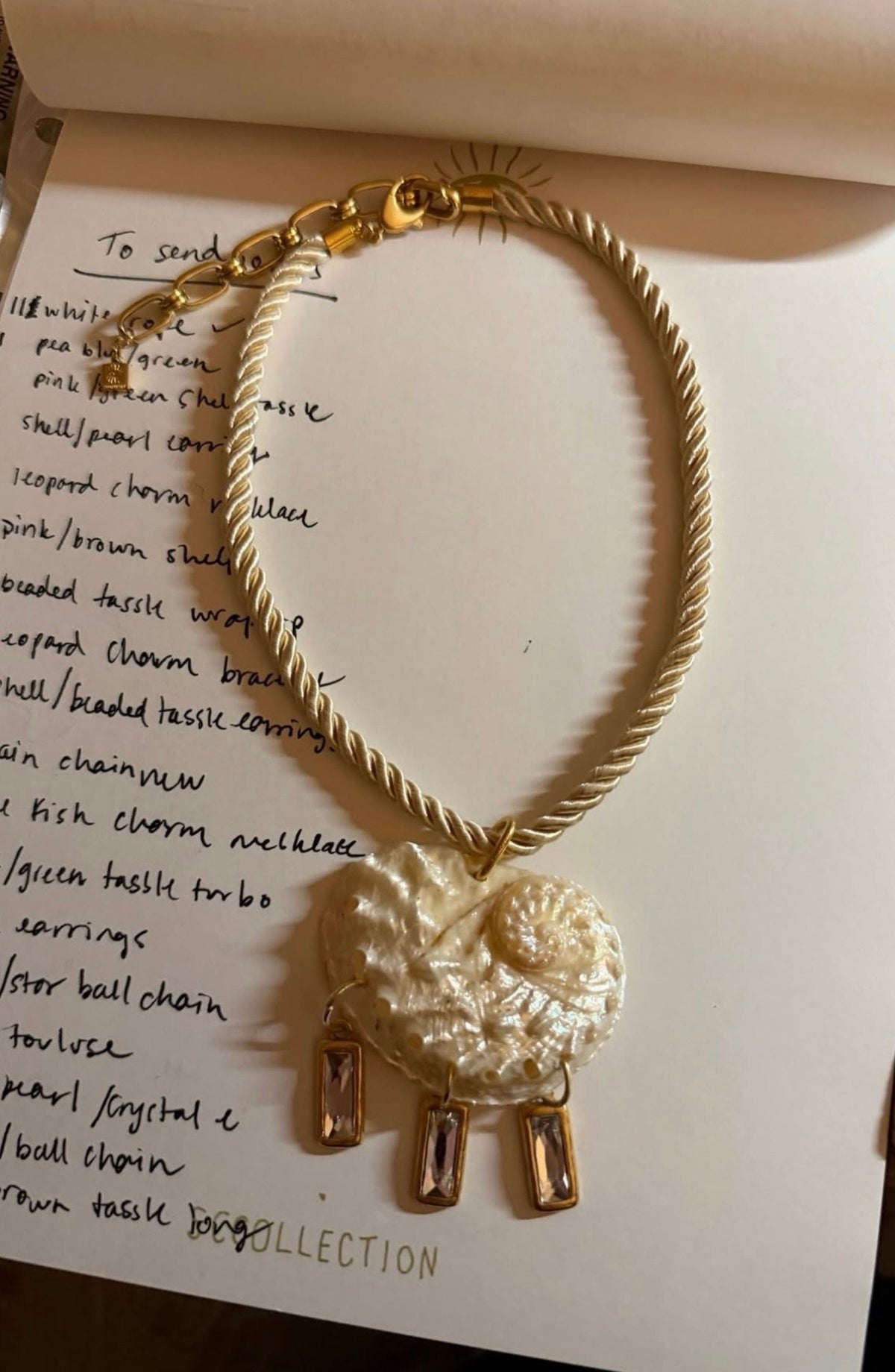 Gold-tone twisted rope choker necklace with textured circular pendant and three rectangular crystal charms.