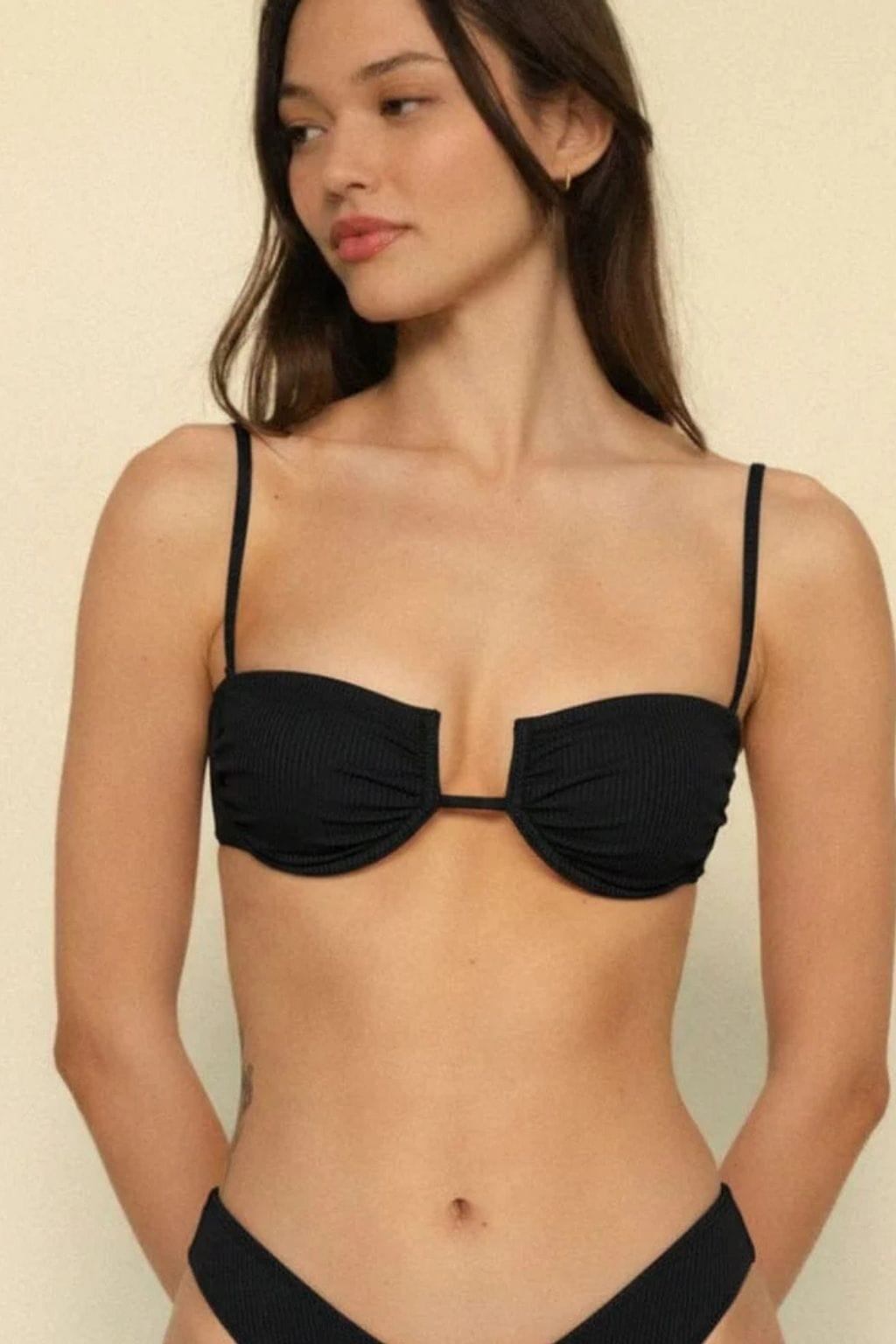 Black ribbed bikini top with thin straps and underwire cups on model.