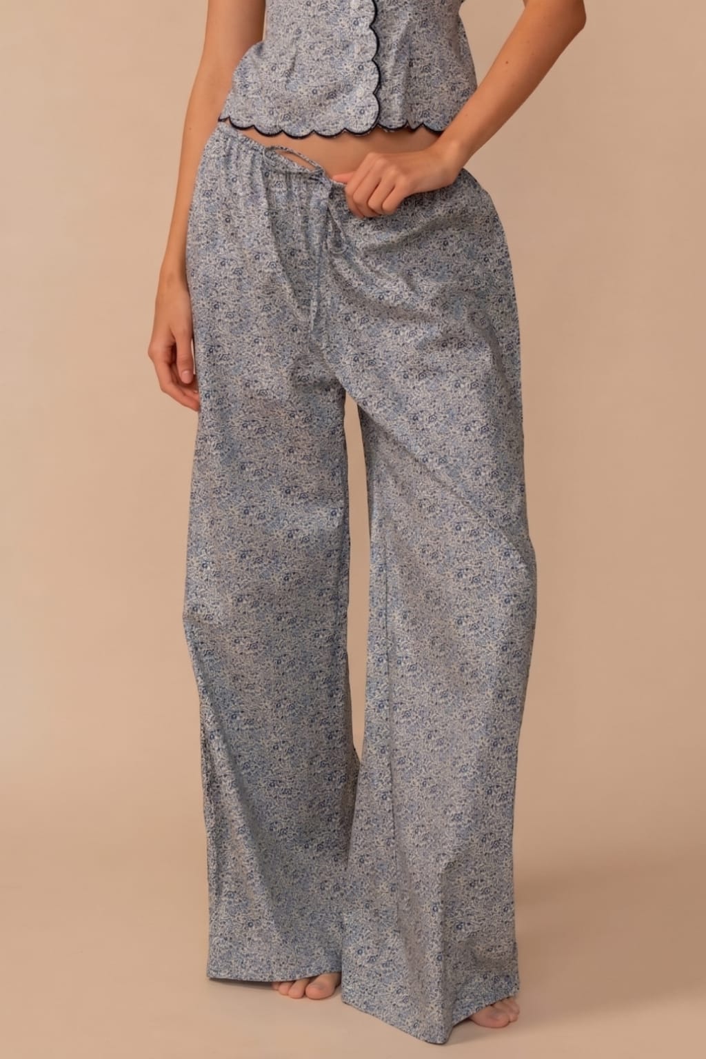 Gray wide-leg pant with drawstring waist and textured knit fabric, styled with matching scalloped crop top.