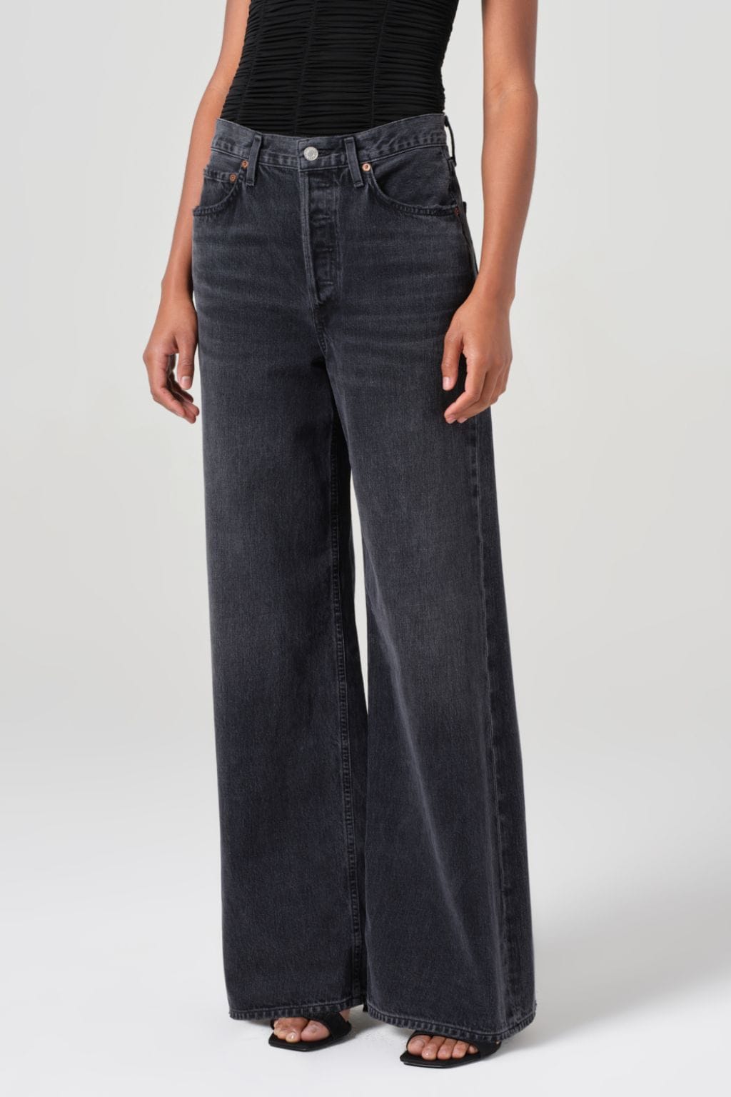 Dark wash wide-leg jeans with high waist, five-pocket styling, and straight hem on model wearing black striped top.