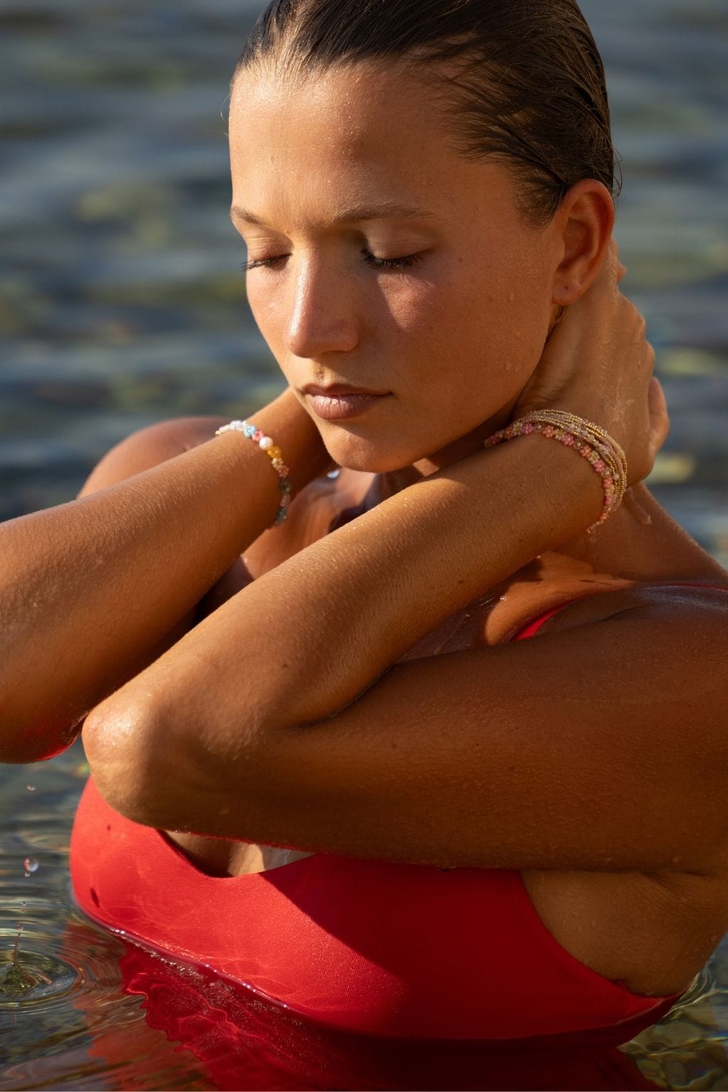 Beaded bracelet in pastel colors worn on wrist in water.
