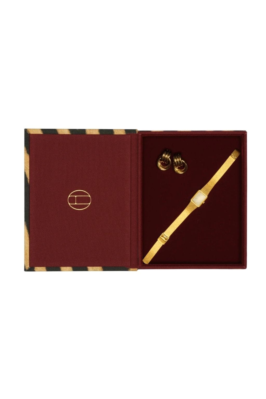 Mini book box with zebra-striped spine containing gold-tone earrings, bracelet, and pen on burgundy interior.