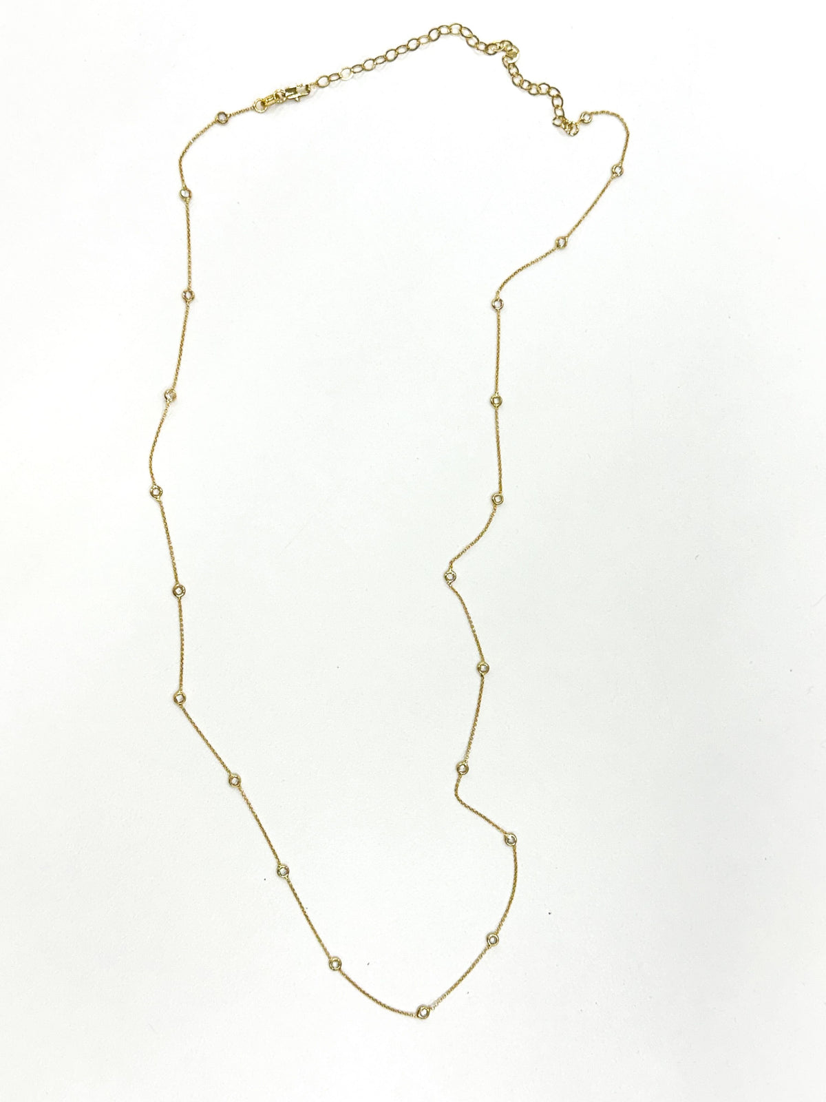 Gold belly chain with small round bezeled crystals spaced along delicate link segments and adjustable clasp.