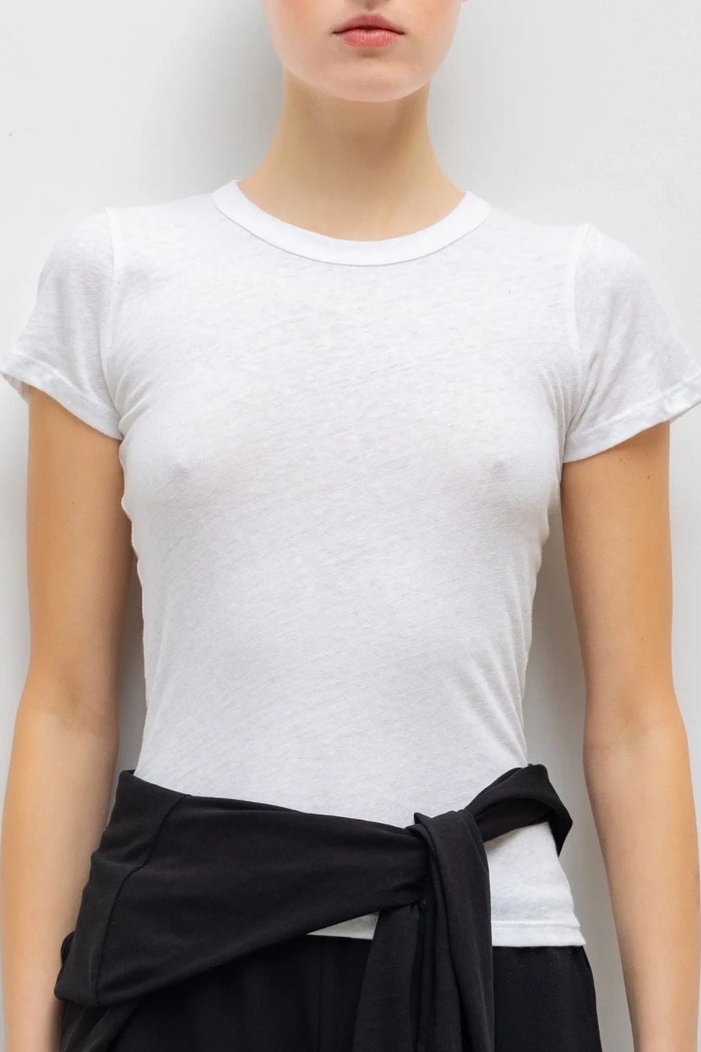 White slim-fit short-sleeve crew neck tee on model paired with black wrap skirt.