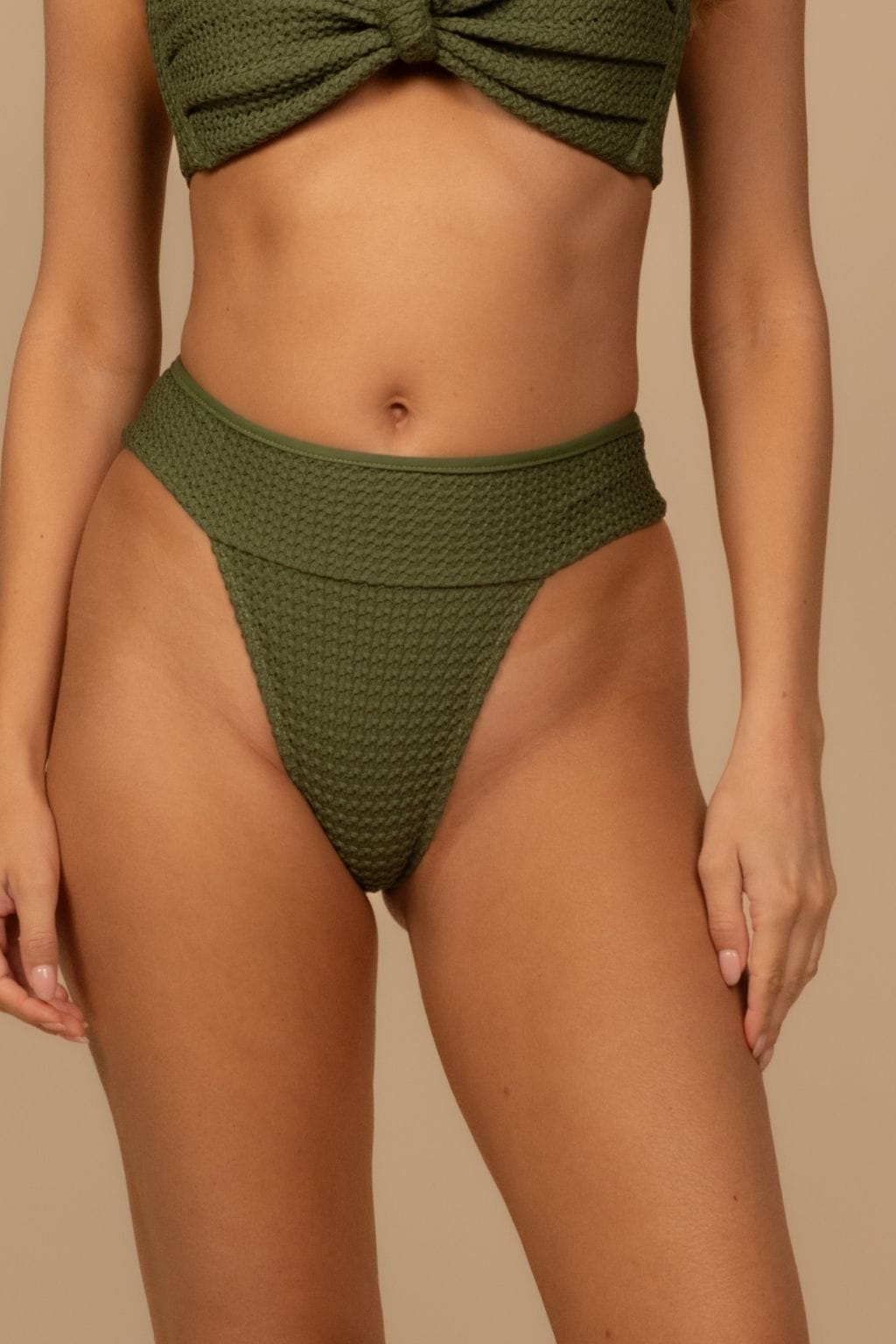 Olive green crochet bikini bottom with textured fabric and folded waistband detail.