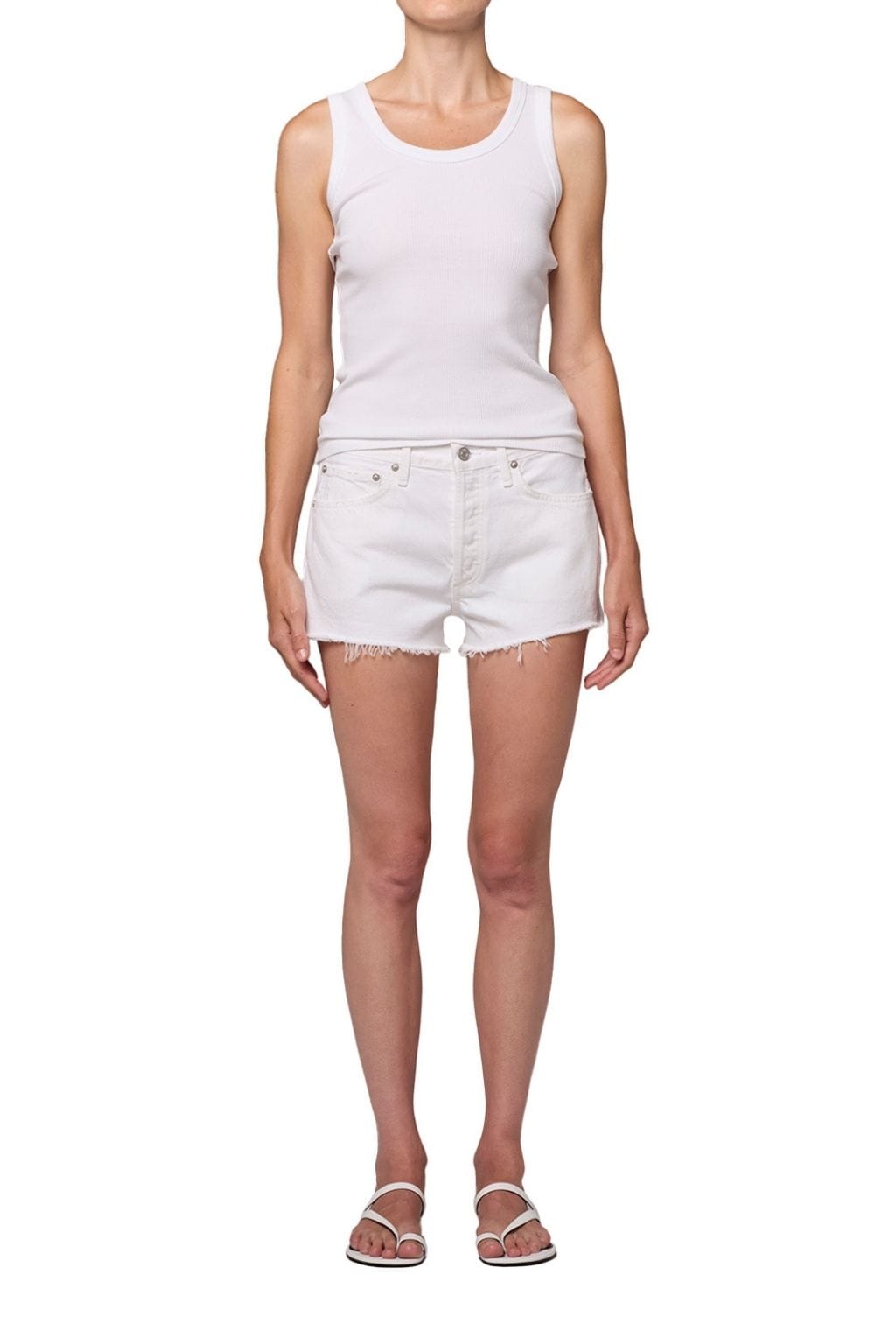 White denim shorts with distressed thighs and frayed edges, worn with a sleeveless white tank top.