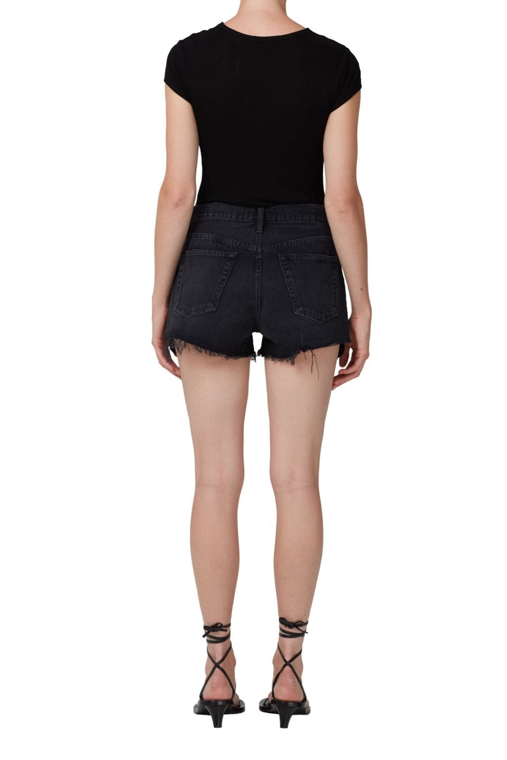Black vintage cut-off denim shorts with distressed edges and frayed hems, styled with black cap-sleeve top.