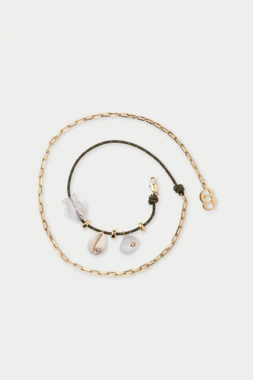 Gold chain anklet with olive cord bracelet featuring shell and stone charms with gold accents.