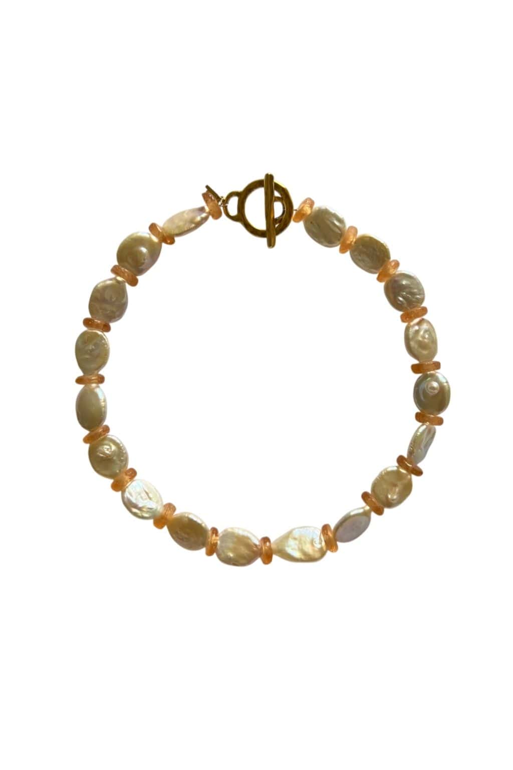 A circular necklace of flat cream freshwater pearls alternating with small peach spacer beads, fastened with a gold toggle clasp at the top.