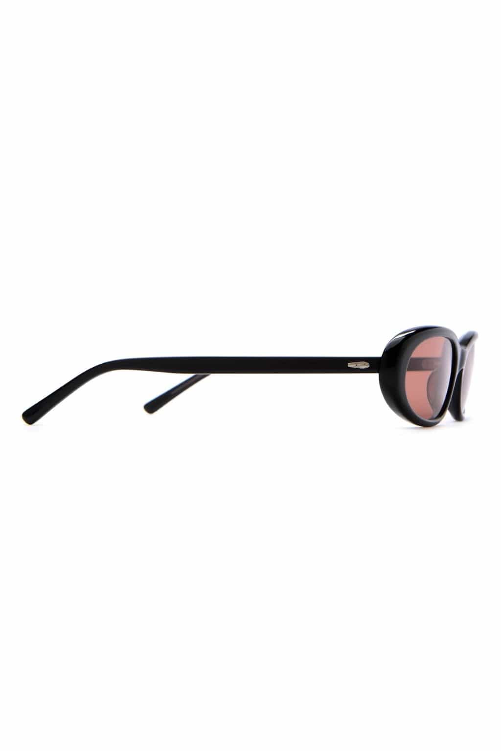 Black oval sunglasses with rose-tinted lenses and black arms, shown from the side.
