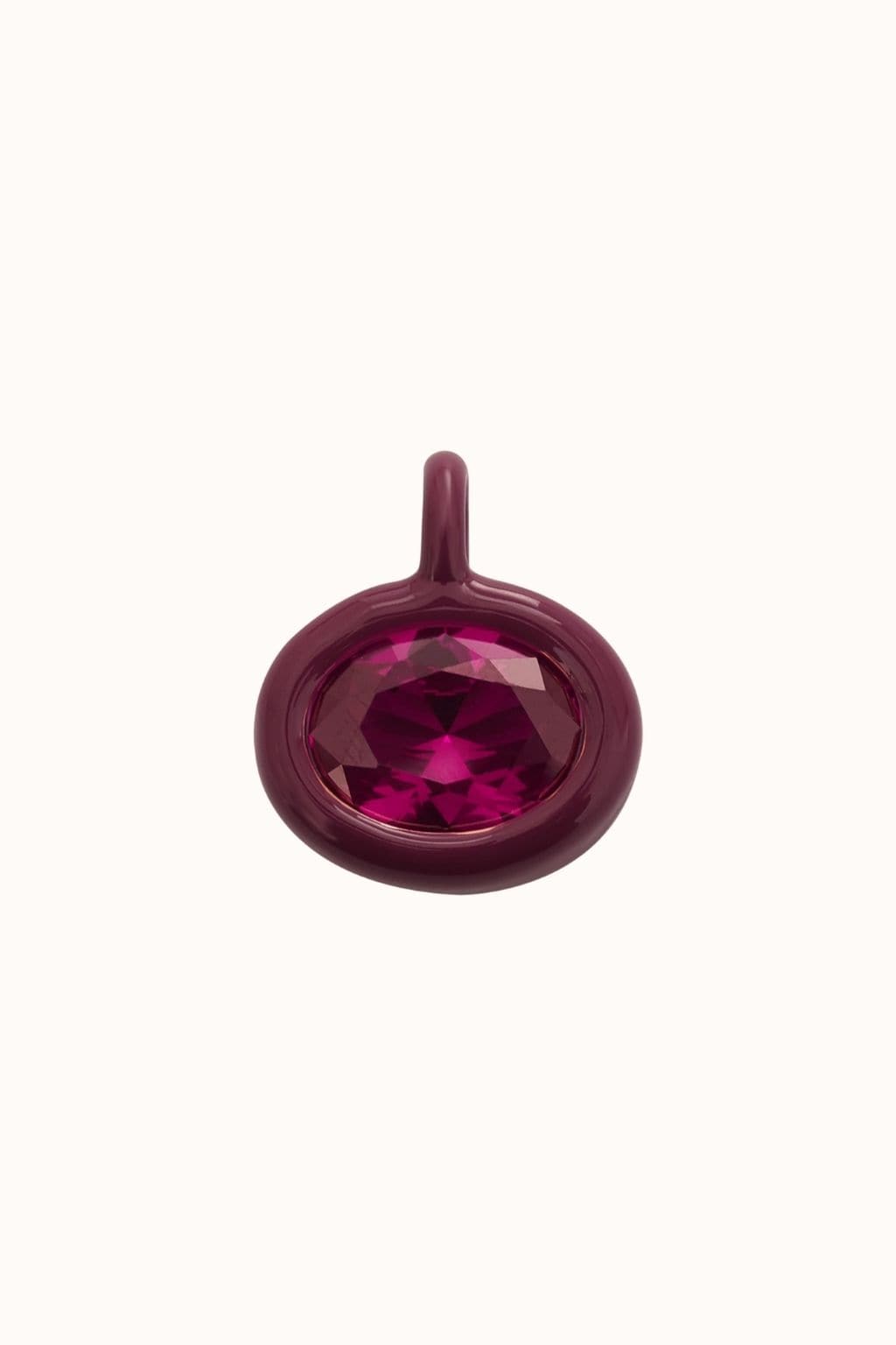 Ruby red charm with faceted gemstone center and loop attachment.