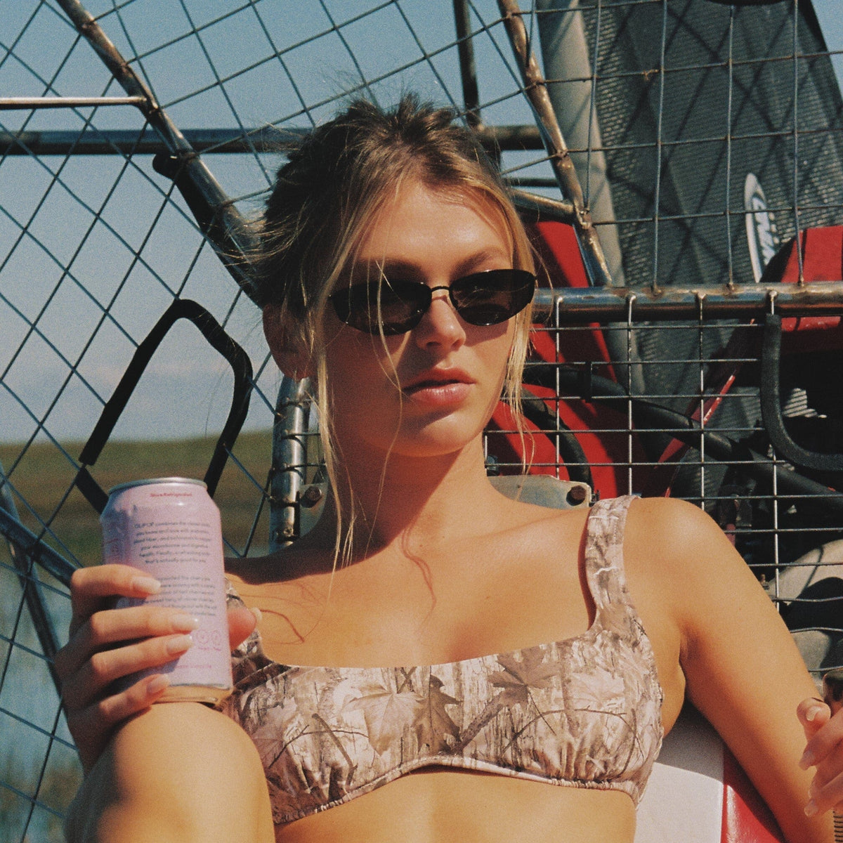 Dark gradient sunglasses with thin metal frames worn by a person outdoors.