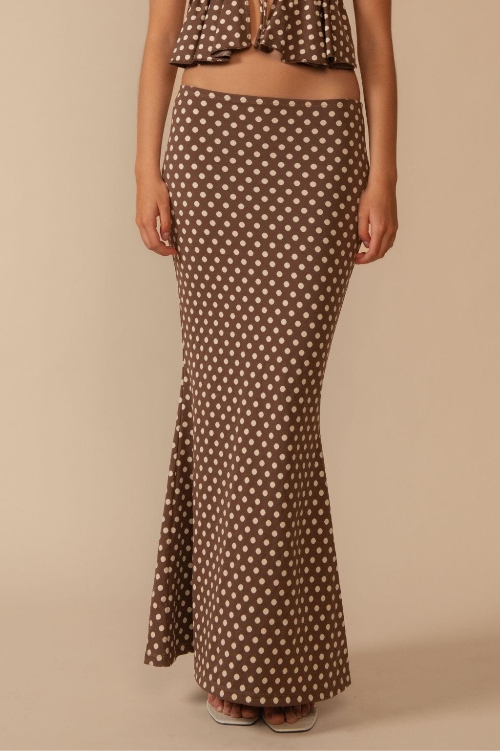 Brown maxi skirt with white polka dot pattern and fitted silhouette.