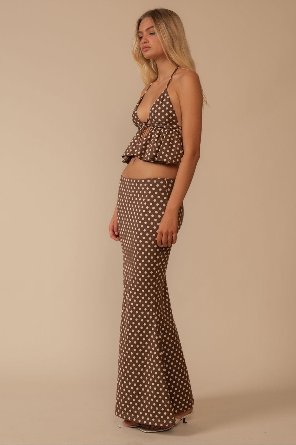 Brown maxi skirt with white polka dot pattern, high-waisted fitted silhouette.
