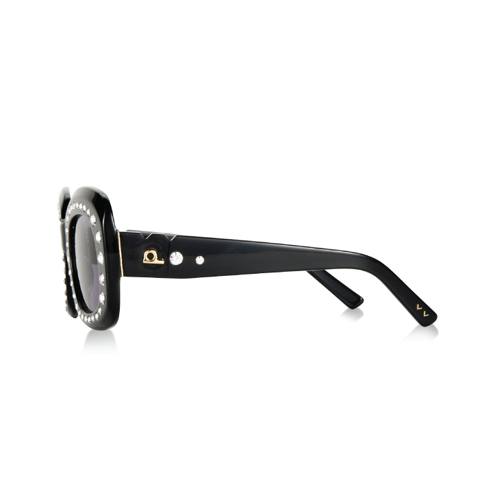 Black oval sunglasses with crystal-embellished frames and gold-tone hardware on temples.