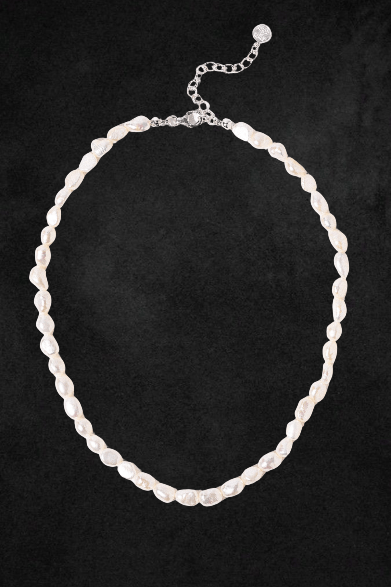White pearl necklace with silver-tone metal clasp and adjustable chain extender on black background.