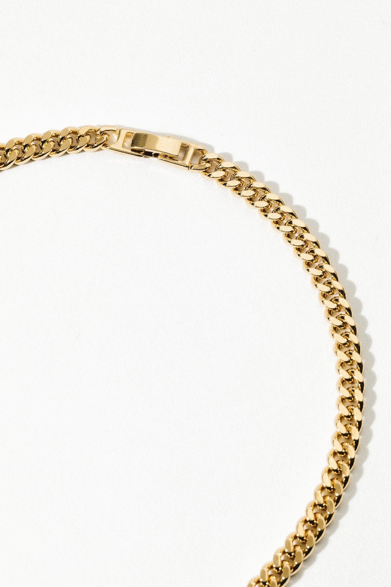 Gold-toned curb chain necklace with rectangular toggle clasp closure.