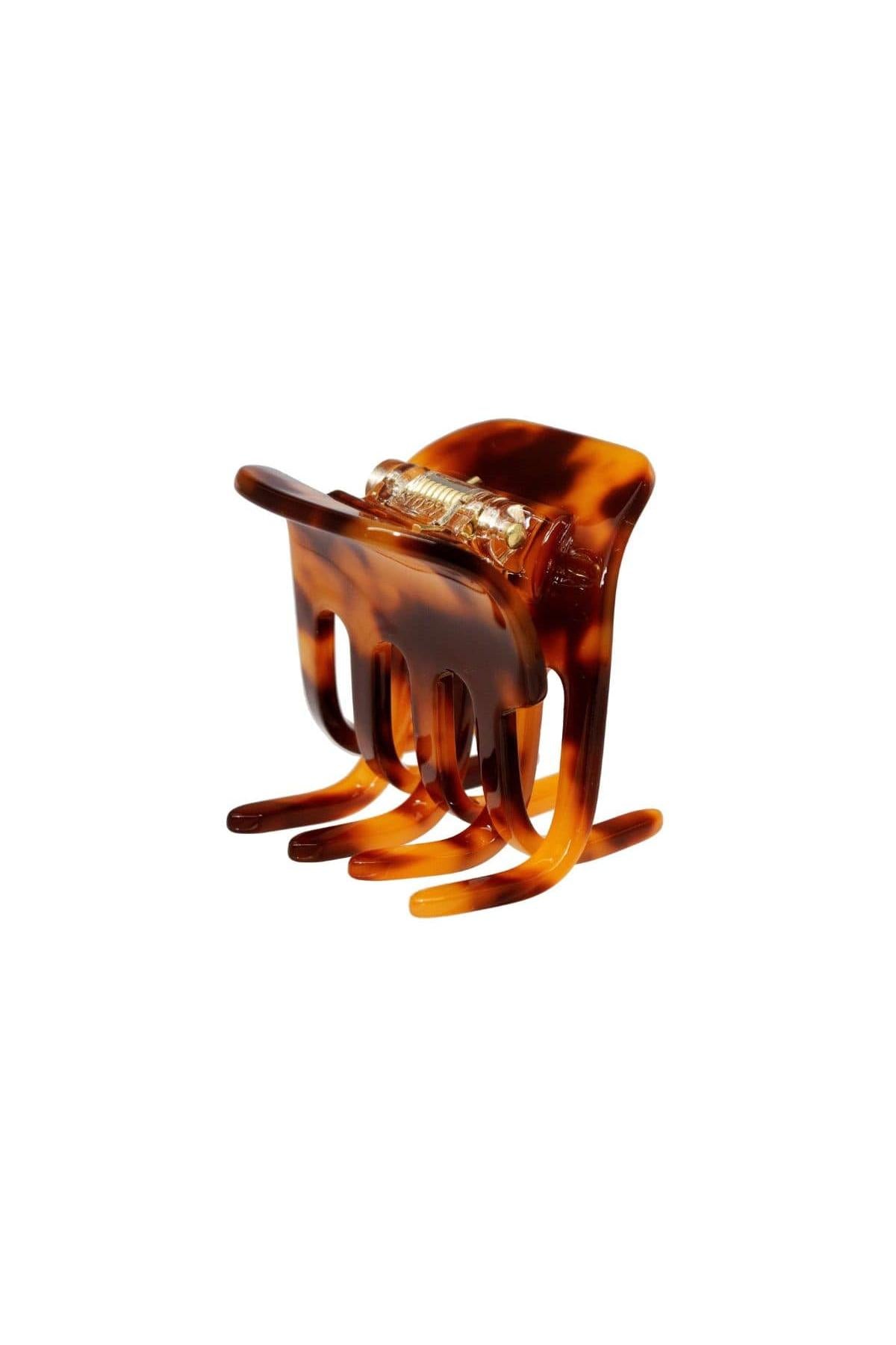 Tortoiseshell plastic hair clip with metal-wrapped center and claw-like prongs for securing hair.