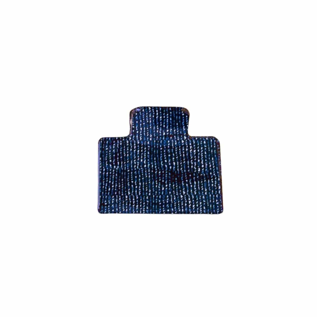Blue denim hair clip with textured weave pattern and rounded rectangular shape.