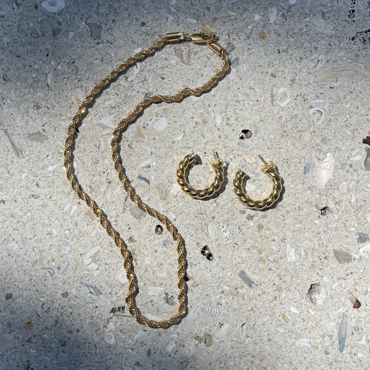 Gold-tone twisted chain necklace with lobster clasp and matching twisted hoop earrings.