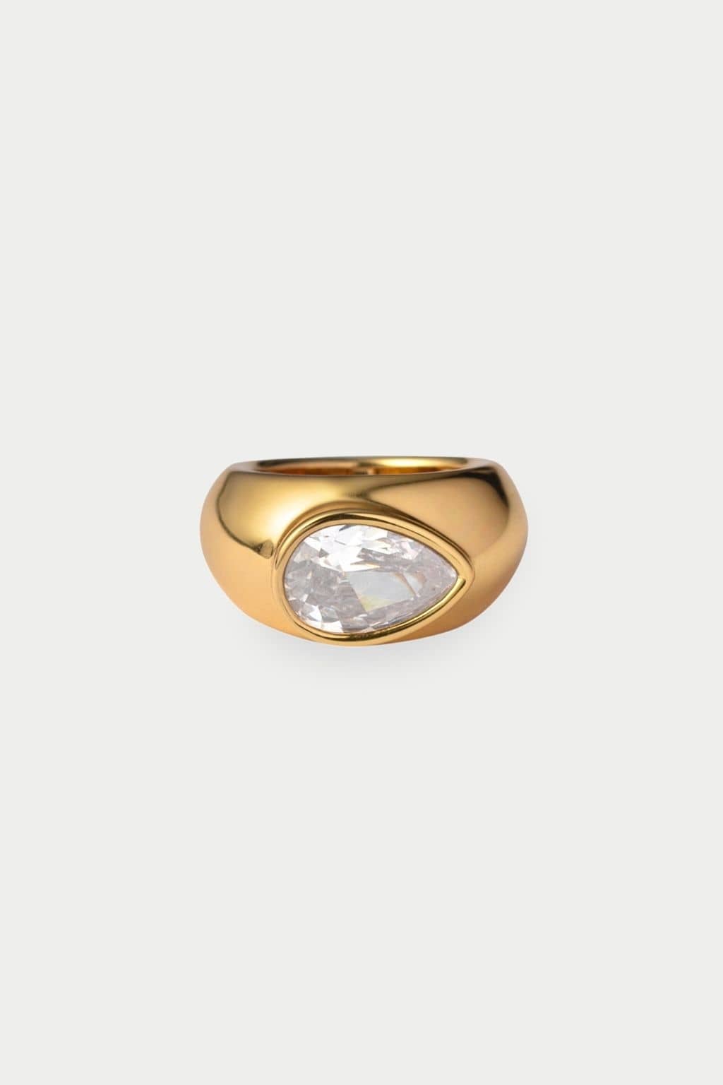 Gold-toned ring with a teardrop-shaped clear crystal stone set in the center.