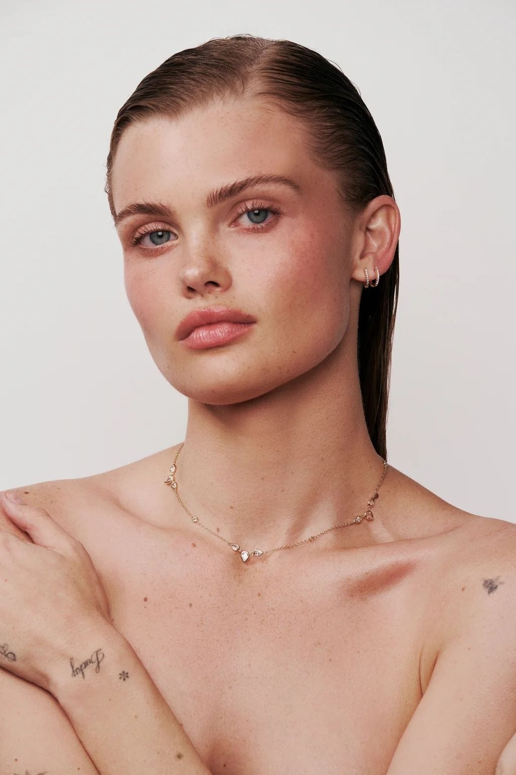 Delicate gold-toned choker necklace with small crystal or diamond-like stones worn close to the neck.
