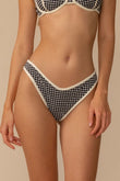 Black and white gingham bikini bottom with cream trim, worn on model.