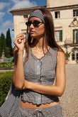 Black and white gingham sleeveless vest with scalloped edges worn with matching headband.