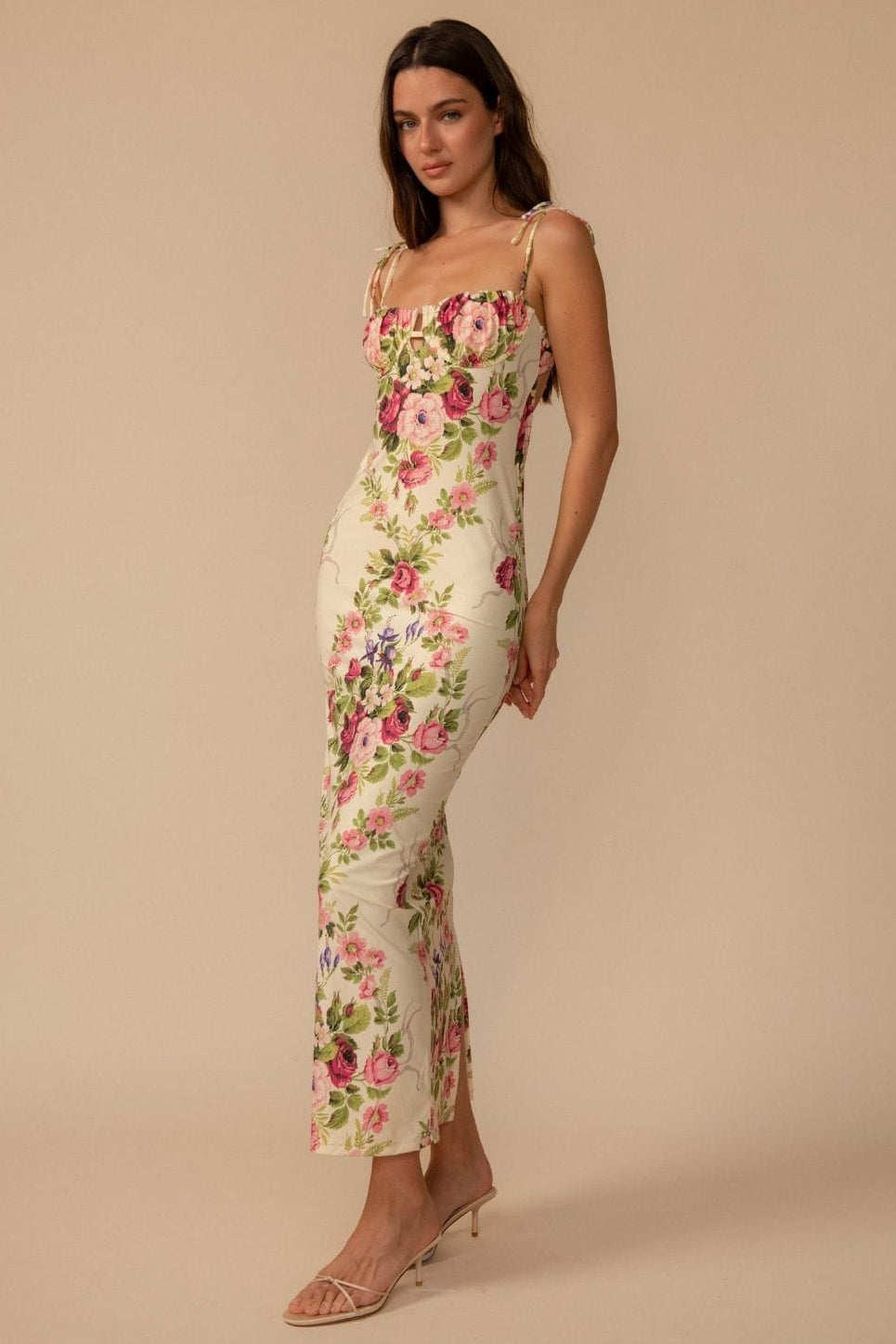 Long slip dress with pink and red floral print on cream background, thin shoulder straps, and fitted silhouette.