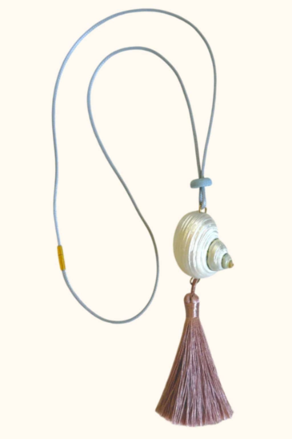Blue and gray cord necklace with white wrapped bead pendant and brown tassel.