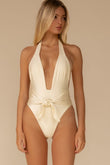 Cream halter one-piece swimsuit with deep V-neckline and tied waist detail.