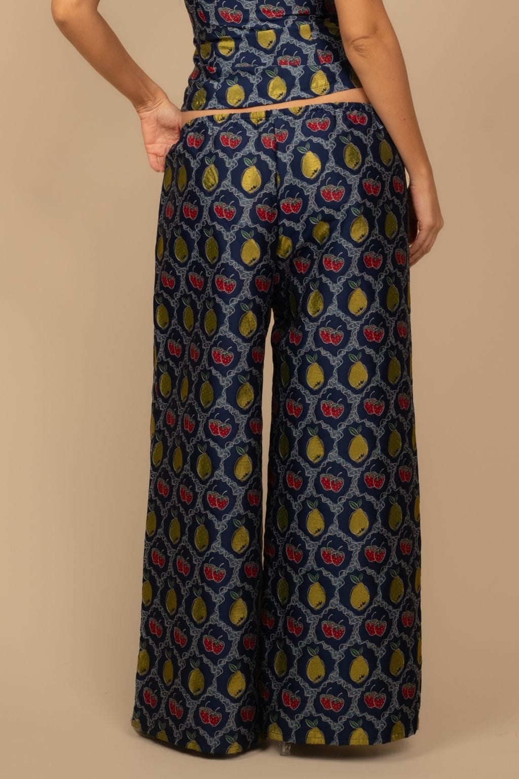 Navy wide-leg pants with red and yellow fruit jacquard pattern and drawstring waist.