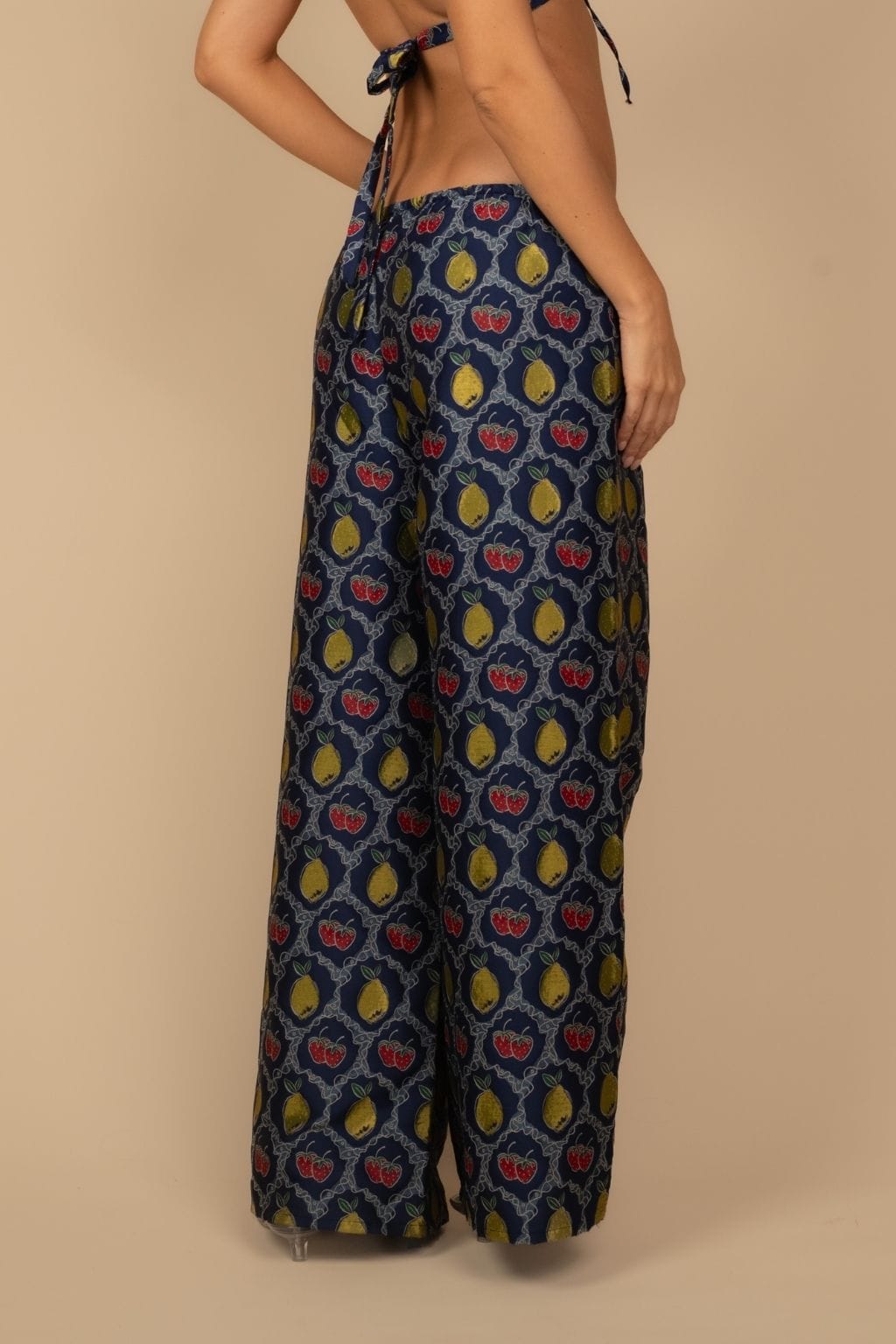 Wide-leg pant with navy jacquard fruit pattern featuring red apples and yellow pears, drawstring waist.