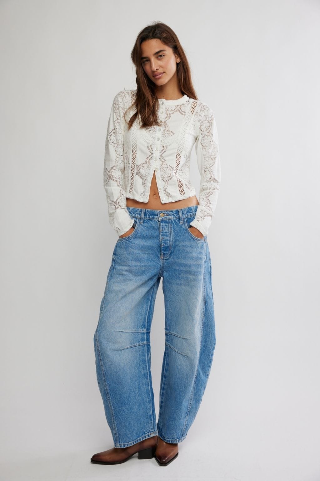 Light wash barrel jeans with high waist, wide leg, and side pocket cutouts styled with white lace top.