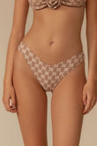 Beige lace bikini bottom with zig-zag stitch pattern and low-rise waistband on model.