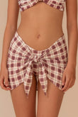 Maroon and cream plaid sarong with tie-front closure worn at waist level.