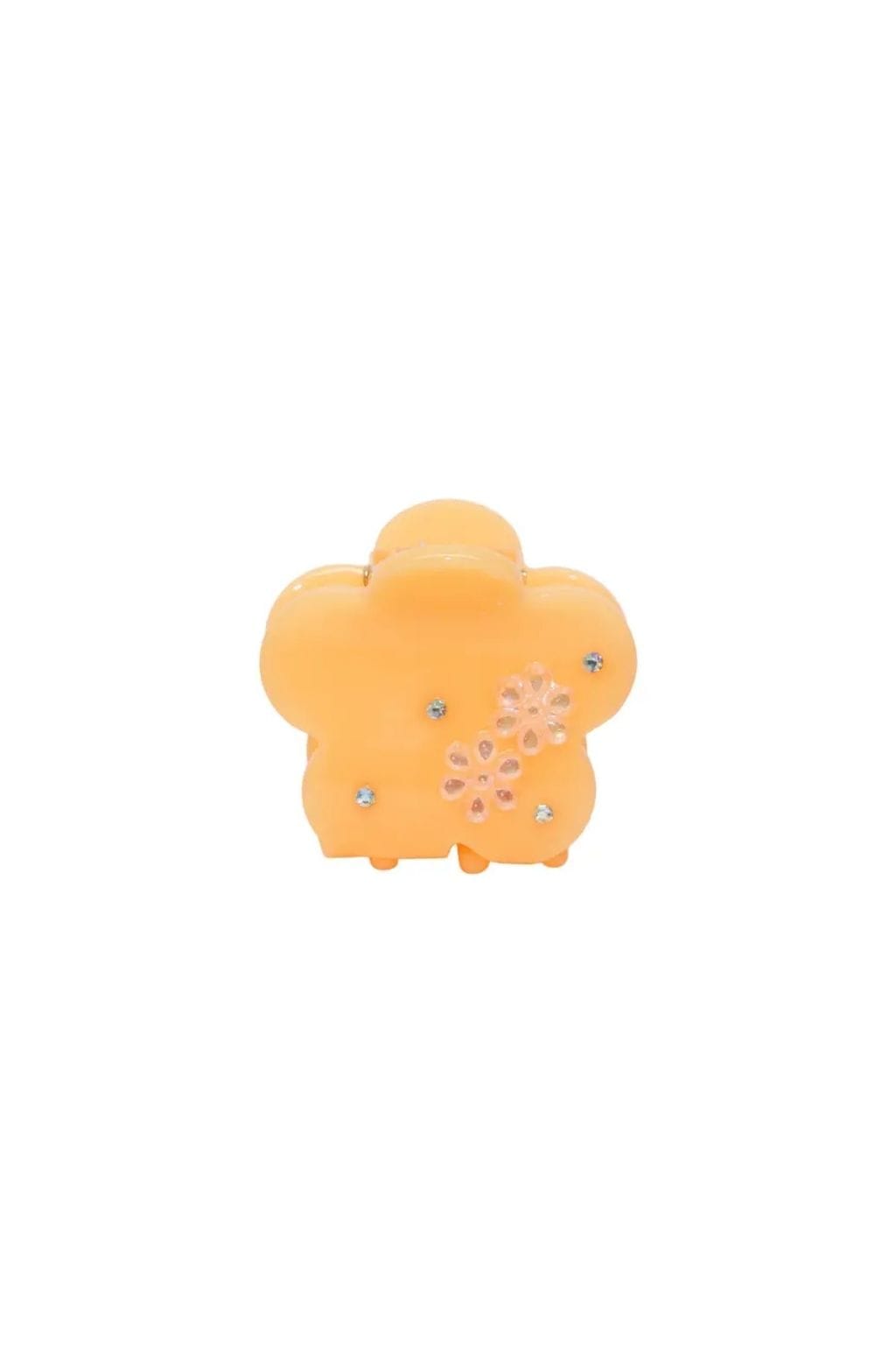 Peach-colored flower-shaped hair clip with rhinestone embellishments and clip closure.