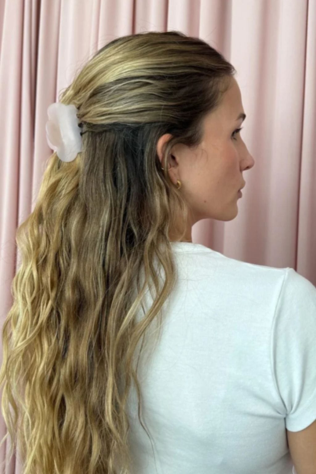 Pink smoke cloud-shaped hair clip worn on long wavy blonde hair, shown in side profile.