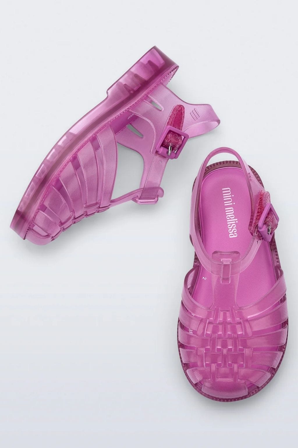 Transparent pink jelly sandal with buckle strap shown from top and bottom views.
