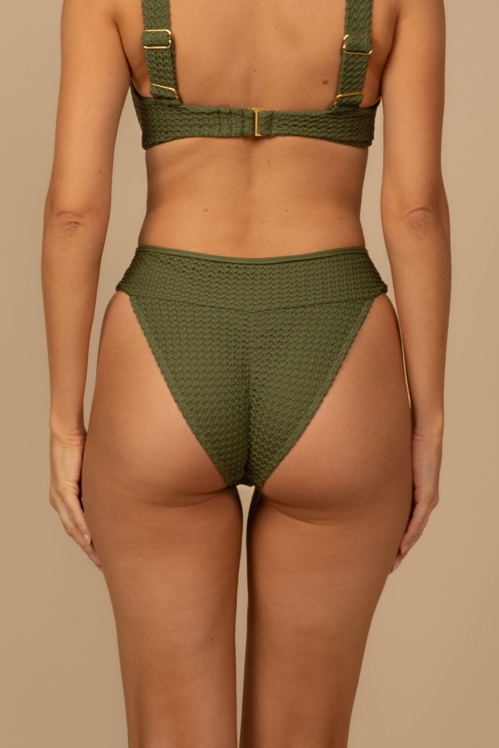 Olive green crochet bikini bottom with textured knit fabric and high-cut sides, shown from back view.
