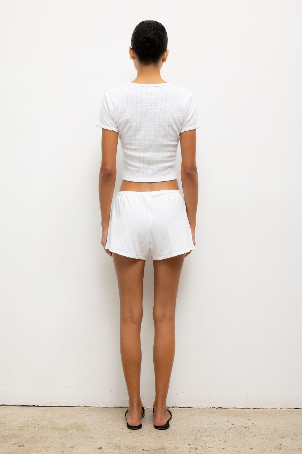 White pointelle shorts with scalloped edges, shown back view with matching short-sleeve top.