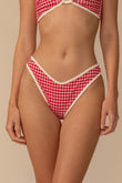 Red and white gingham bikini bottom with cream trim, shown on model from waist down.