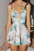 Sleeveless short slip dress with watercolor dye pattern in pink, green, and blue tones, featuring a bow cutout at the bust.