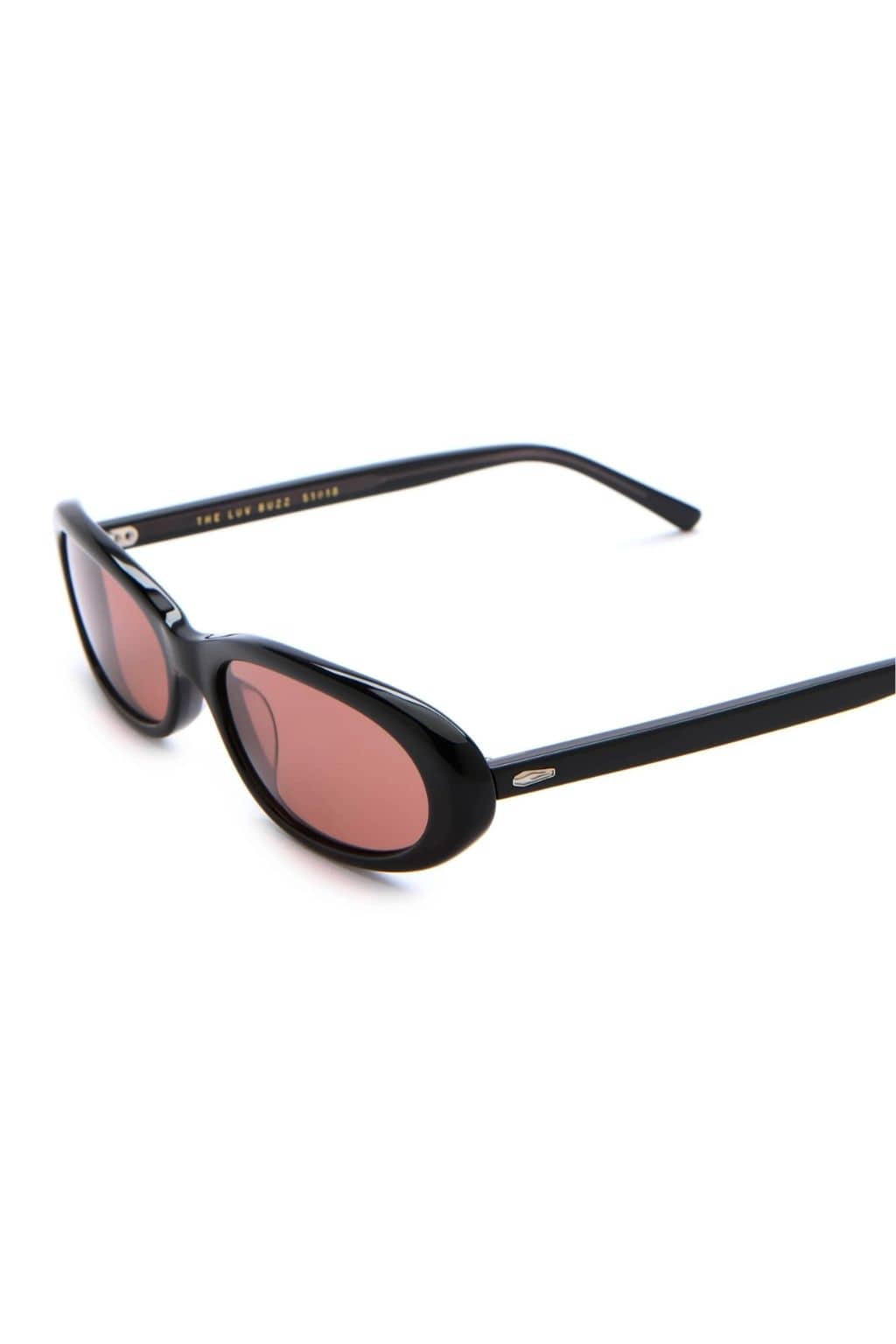 Black oval sunglasses with pink-tinted lenses and metal accents on the frame.