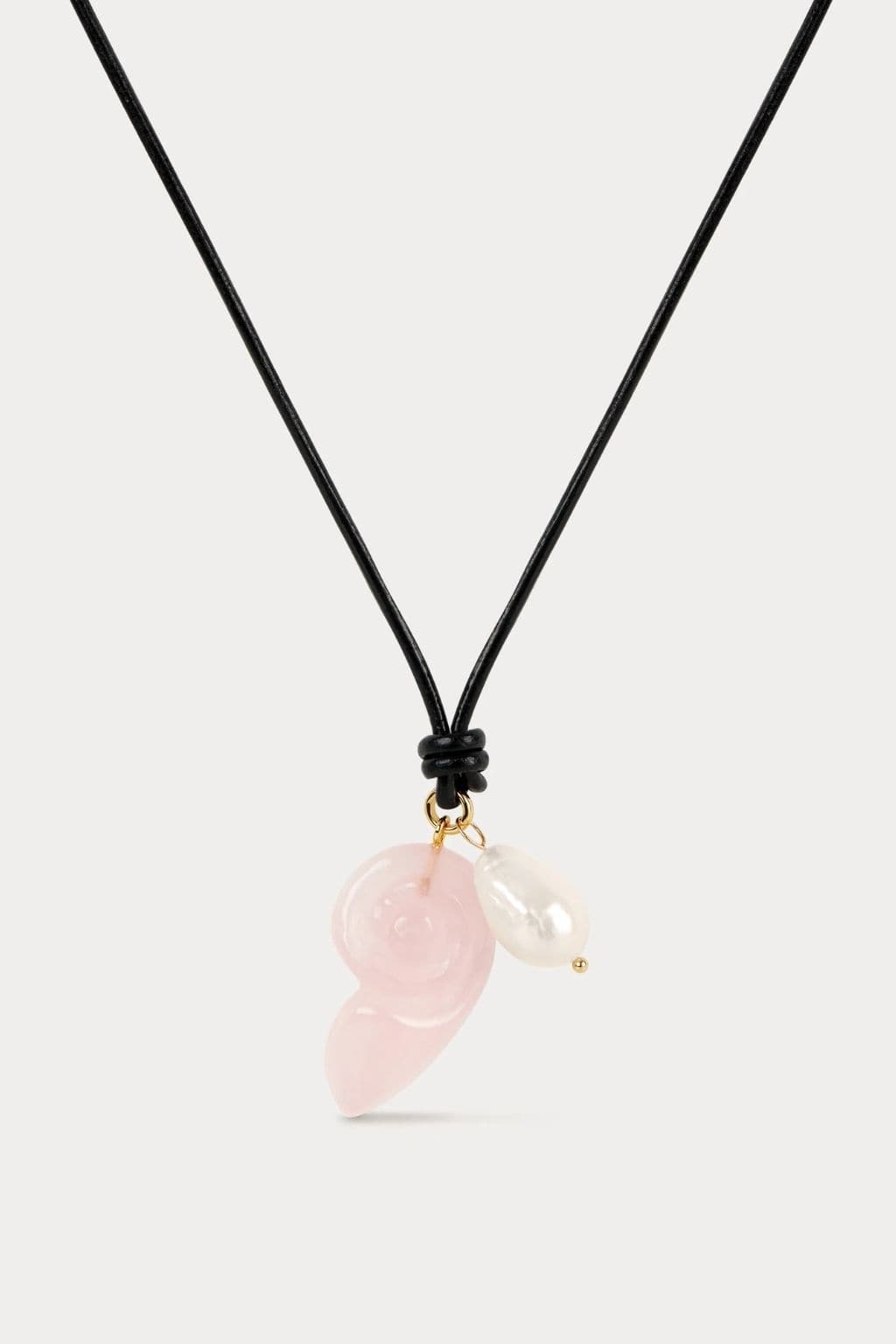 Black cord necklace with pink quartz and white pearl pendant attached with gold-tone hardware.