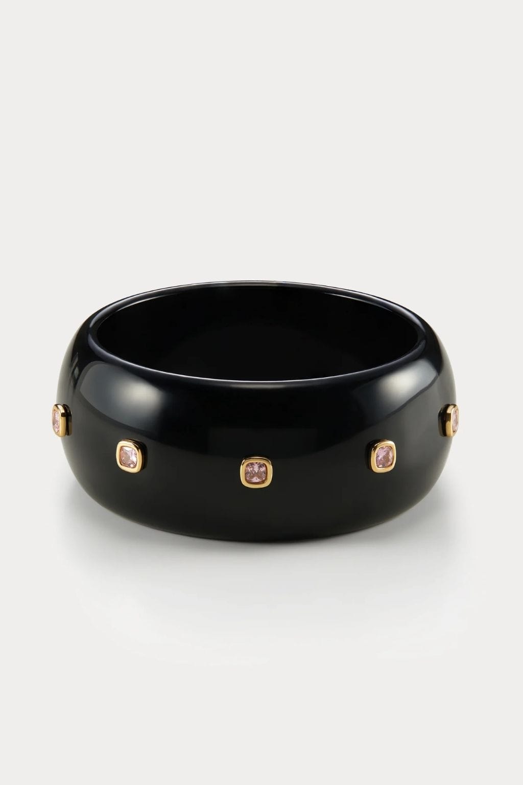 Black lucite cuff bracelet with gold-tone settings and clear crystal embellishments on sides.