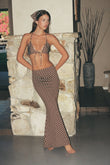Brown maxi skirt with white polka dots, worn with matching halter bikini top.