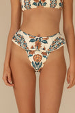 Cream bikini bottom with orange and teal floral print and ruffled side edges.