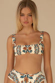 Bikini top with cream, orange, and teal floral print, square neckline, and adjustable straps.