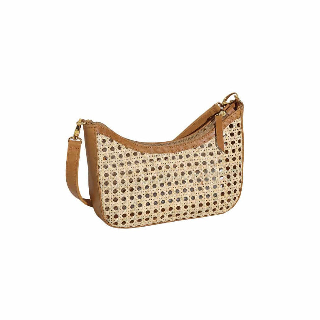 Elba bag with woven cream-colored perforated body, tan leather trim, and adjustable shoulder strap.